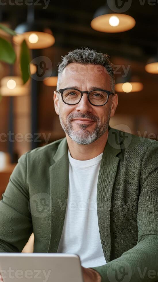 Business professional smiling in a modern workspace while using a laptop during the afternoon photo