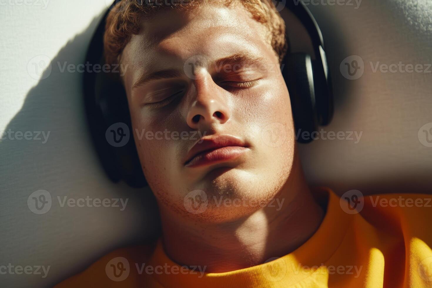 Relaxing young man enjoying music with headphones in a casual setting during the afternoon light photo