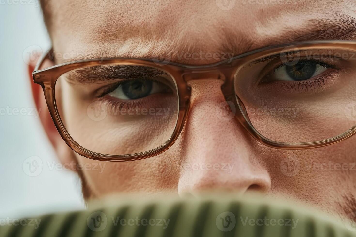 Intense gaze of a young man with glasses showing emotion and focus in a close-up portrait photo
