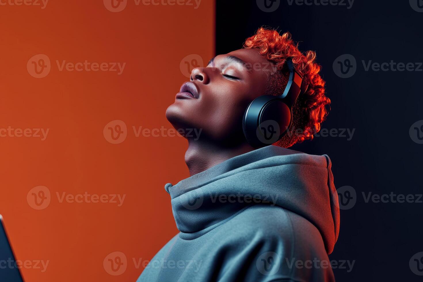 Young man enjoying music with headphones in a modern, colorful setting during the evening hours photo