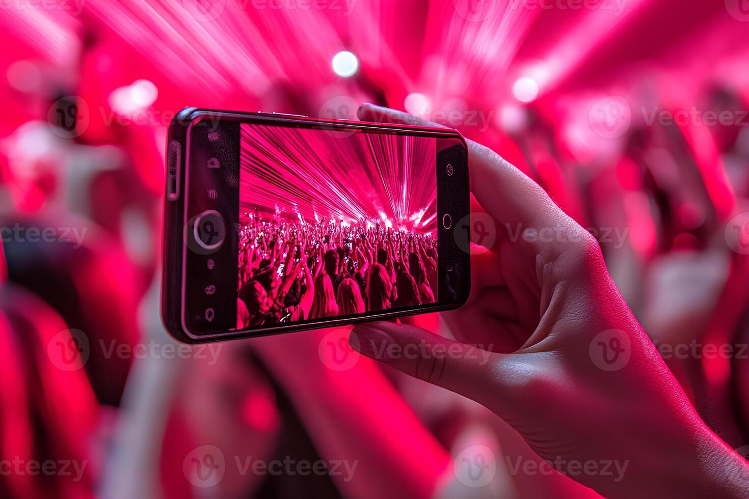 Hand with smart phone taking a photo of a concert with a crowd