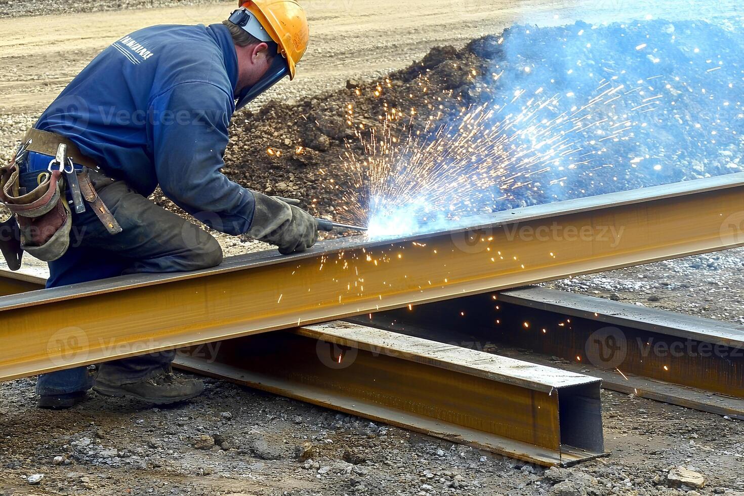 Industrial worker welding metal structures during the construction of a new road in an urban environment with bright sparks flying photo