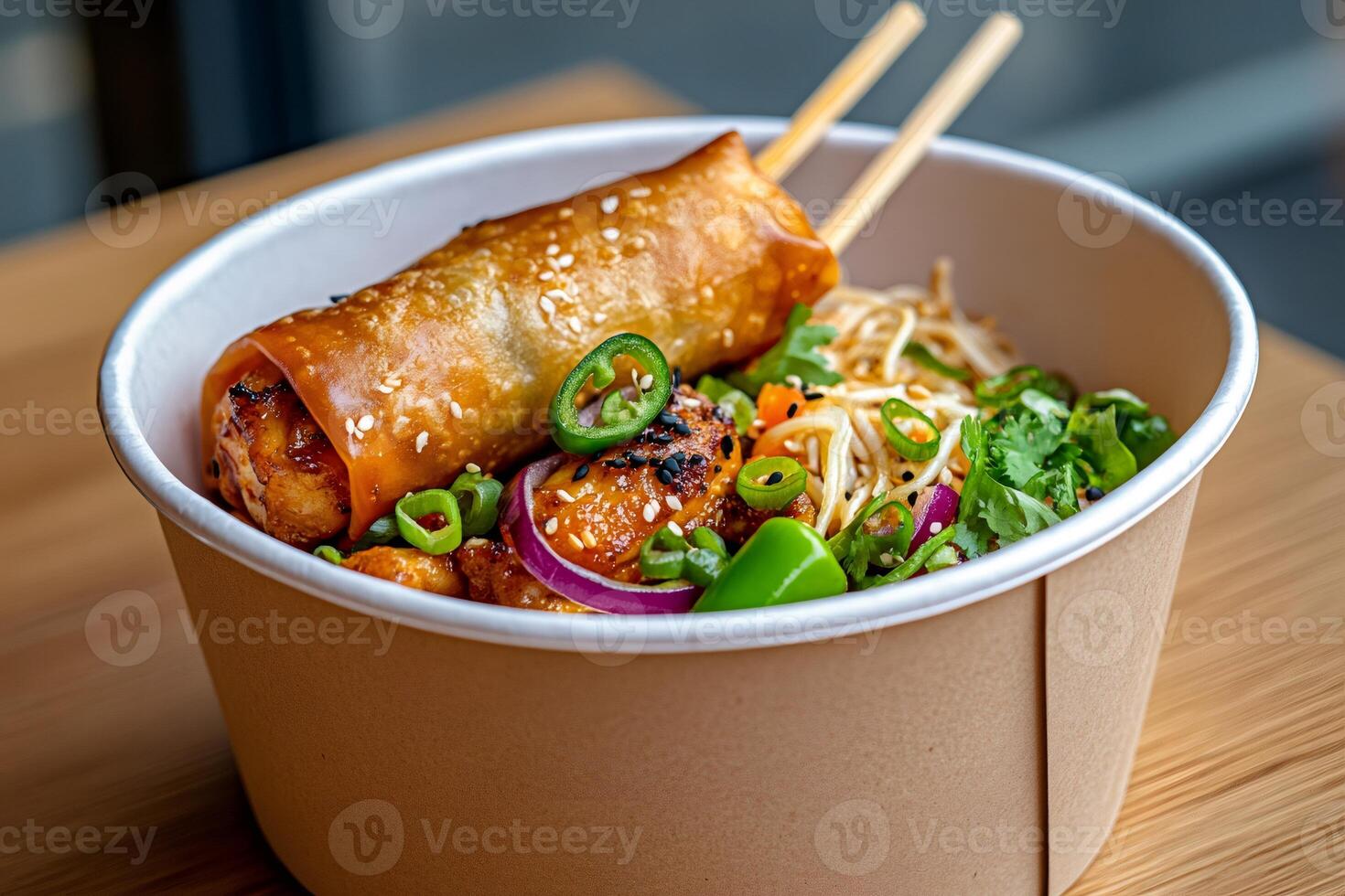 Crispy spring roll with sesame seeds topping a bowl of chicken and noodles photo