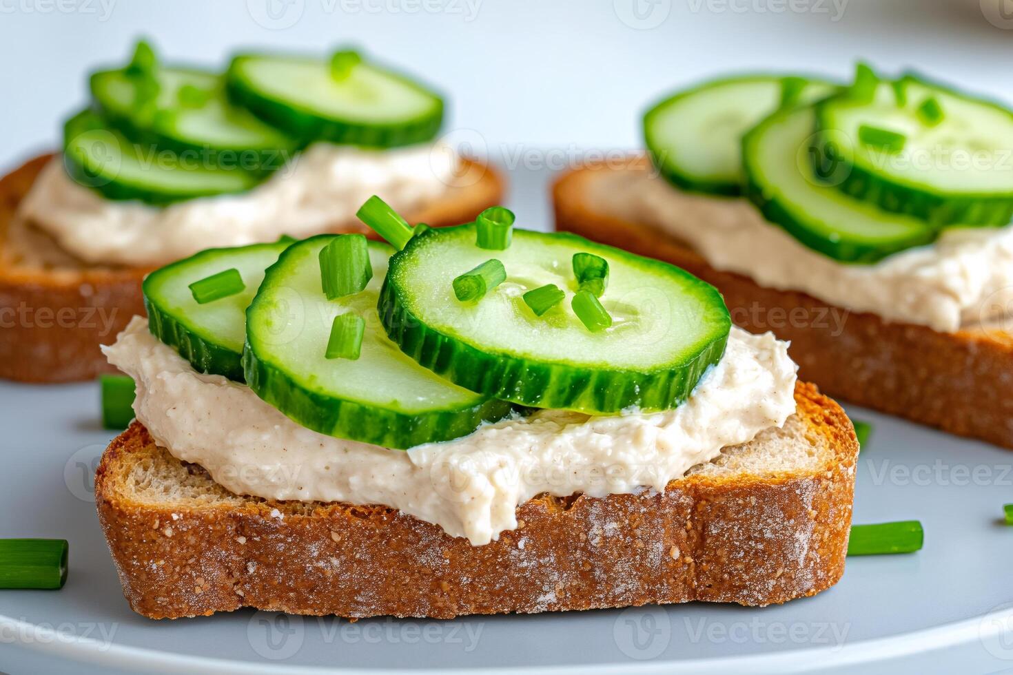 Delicious with toasted bread, cream cheese and cucumber slices garnished with chives photo