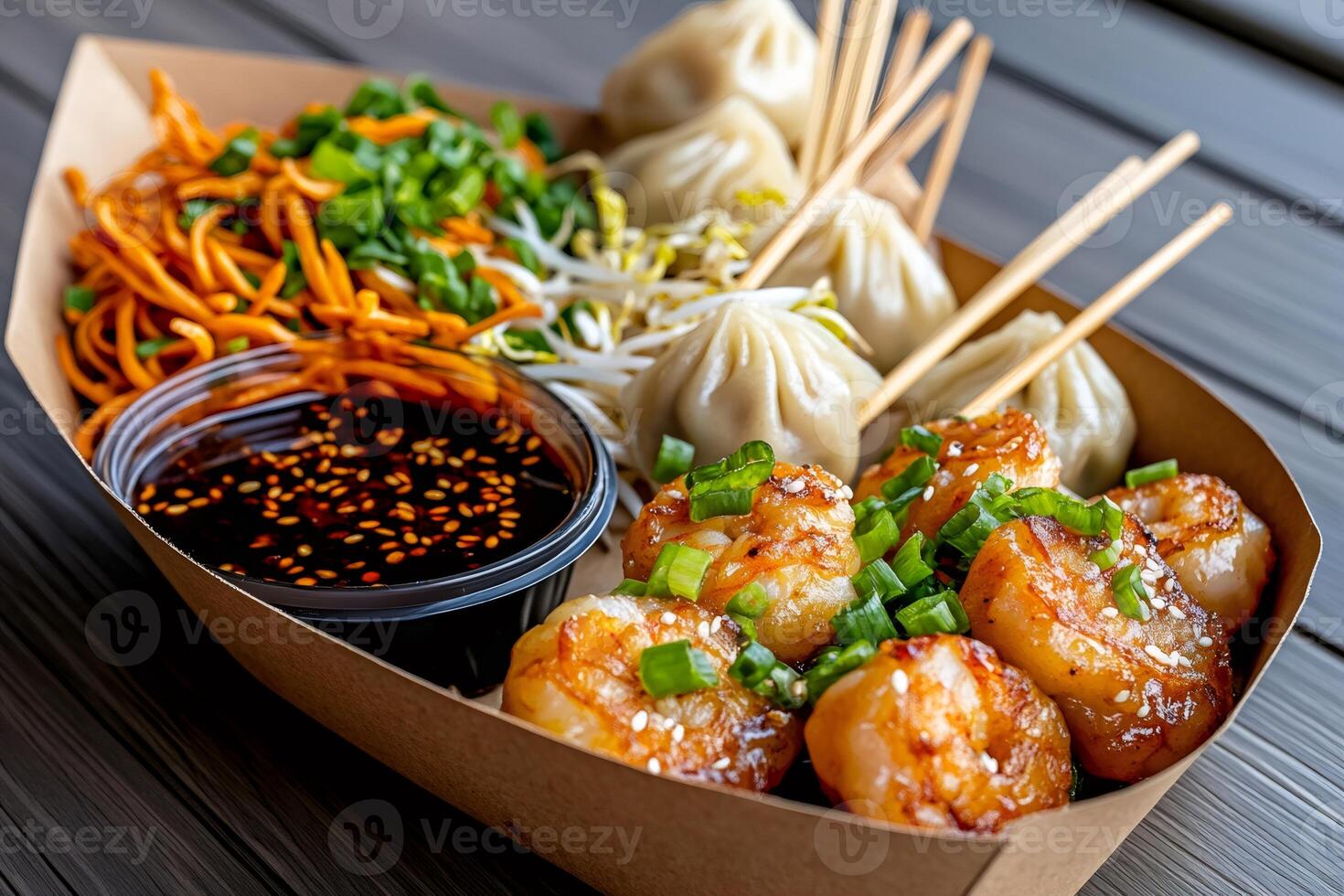 Delicious asian food box with fried shrimps, dim sum, soy sauce, carrot noodles and bean sprouts photo