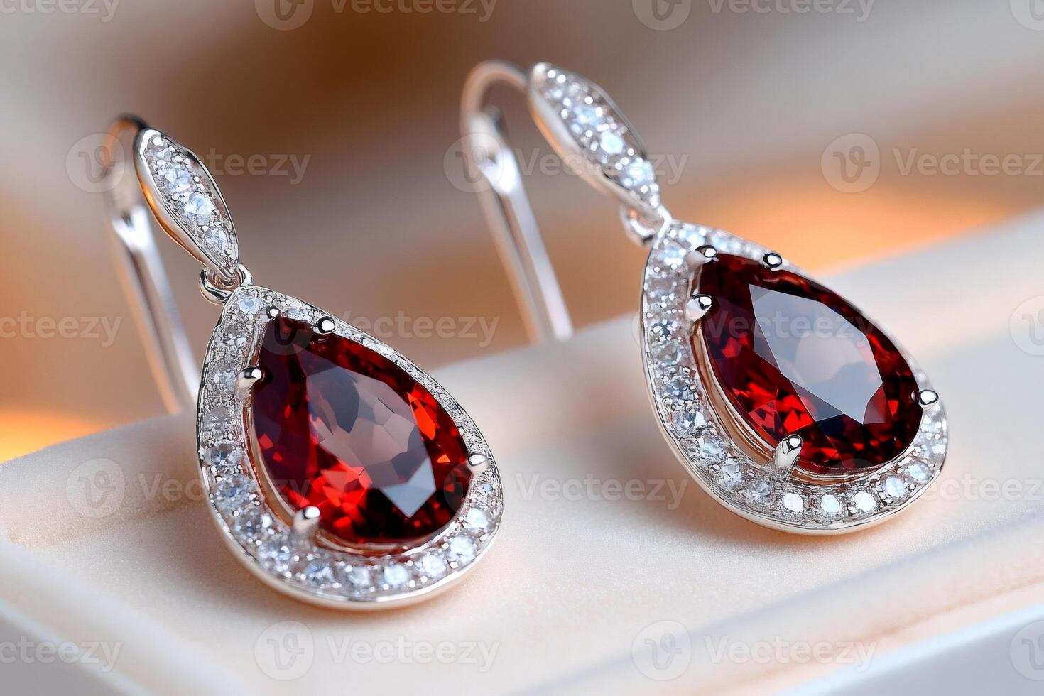 Beautiful earrings with red garnet and diamonds shining on soft background photo