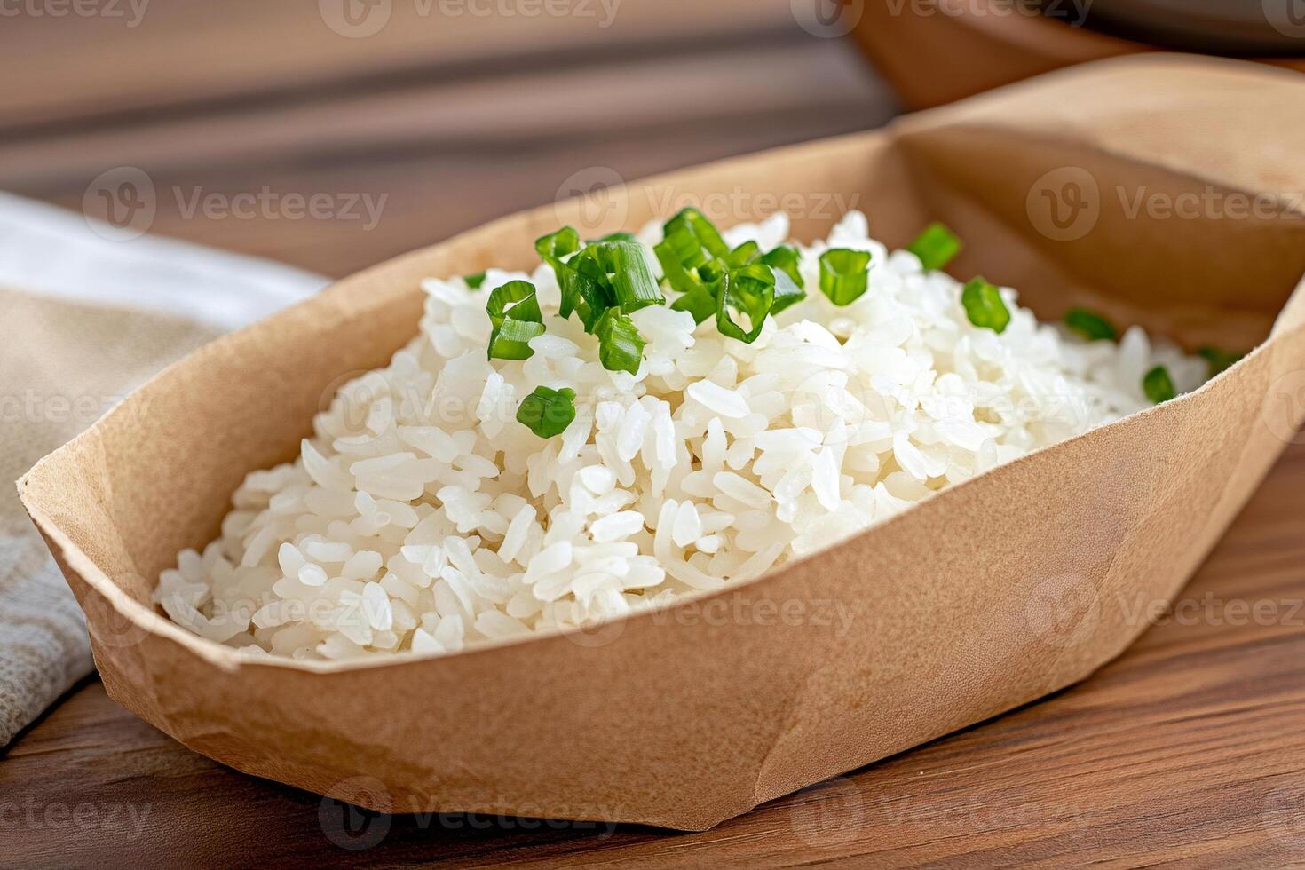 Steamed rice garnished with chopped chives served in a takeaway container photo