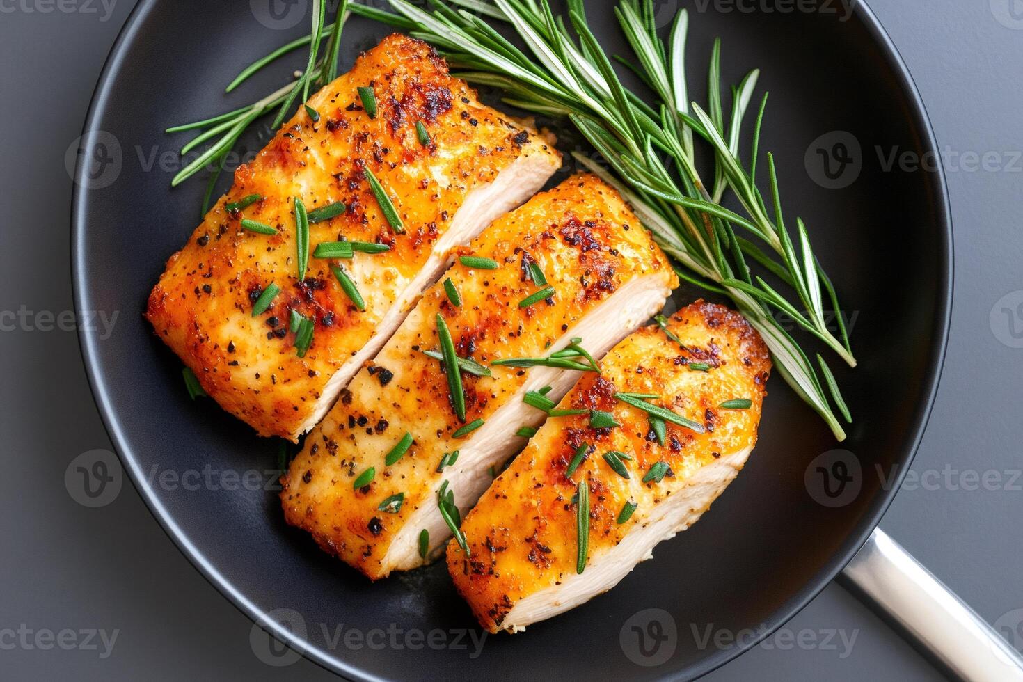Sliced roasted chicken breast with rosemary in a pan photo