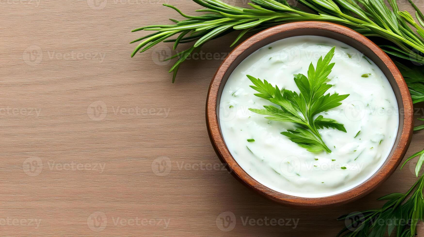 Wooden bowl with creamy sauce and herbs on wooden table photo