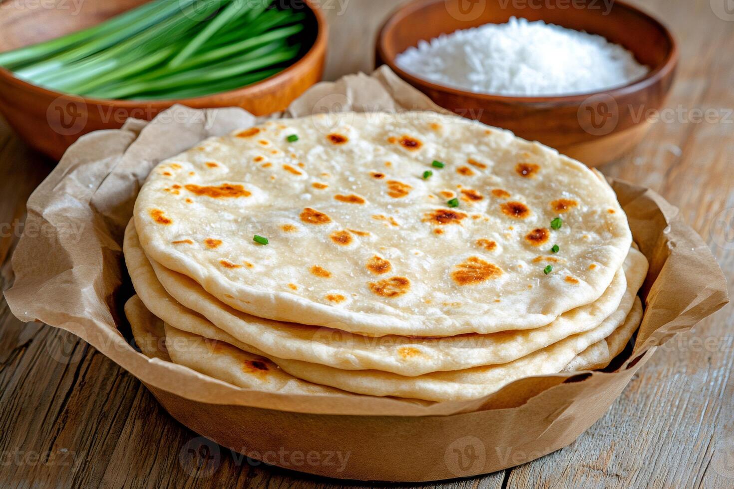 Delicious homemade flour tortillas garnished with chopped chives resting on baking paper photo