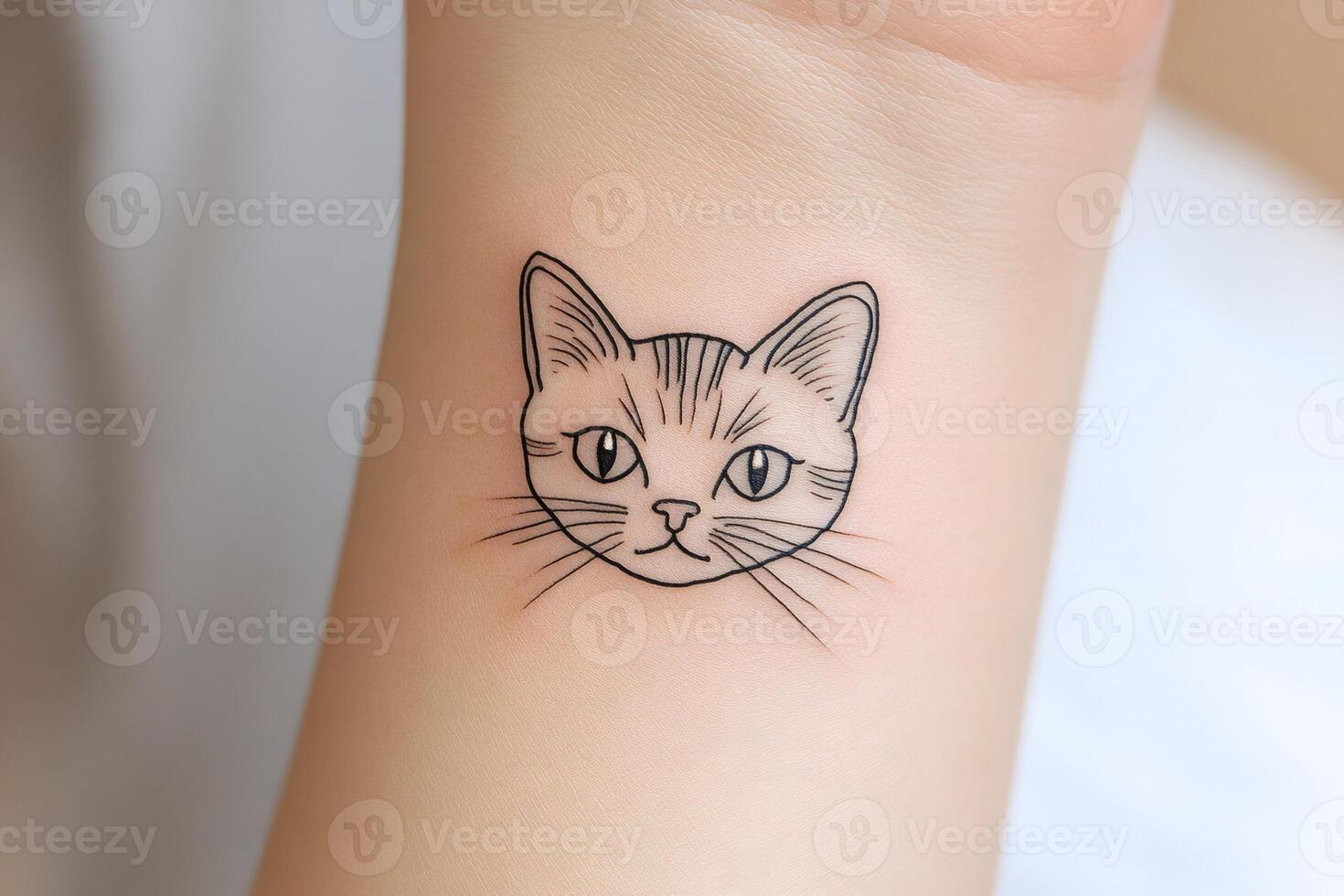 Minimalist cat tattoo being drawn on wrist photo