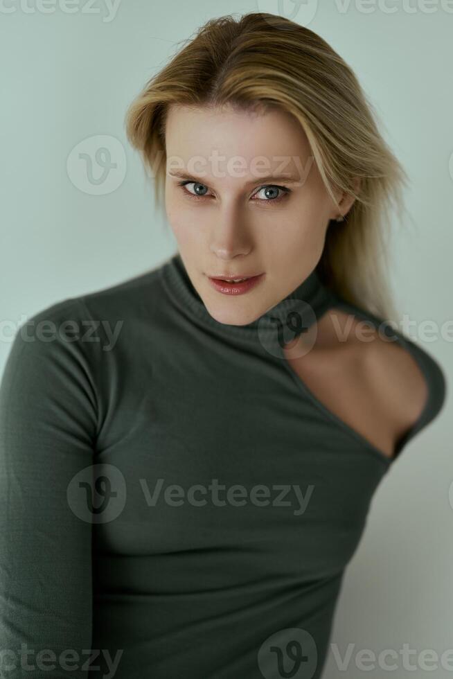 Young beautiful ballerina in a black bodysuit posing on a studio photo