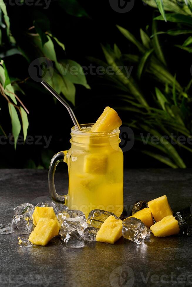 pineapple drink or iced lemonade in a mason jar. Pineapple lemonade with pineapple pieces. photo