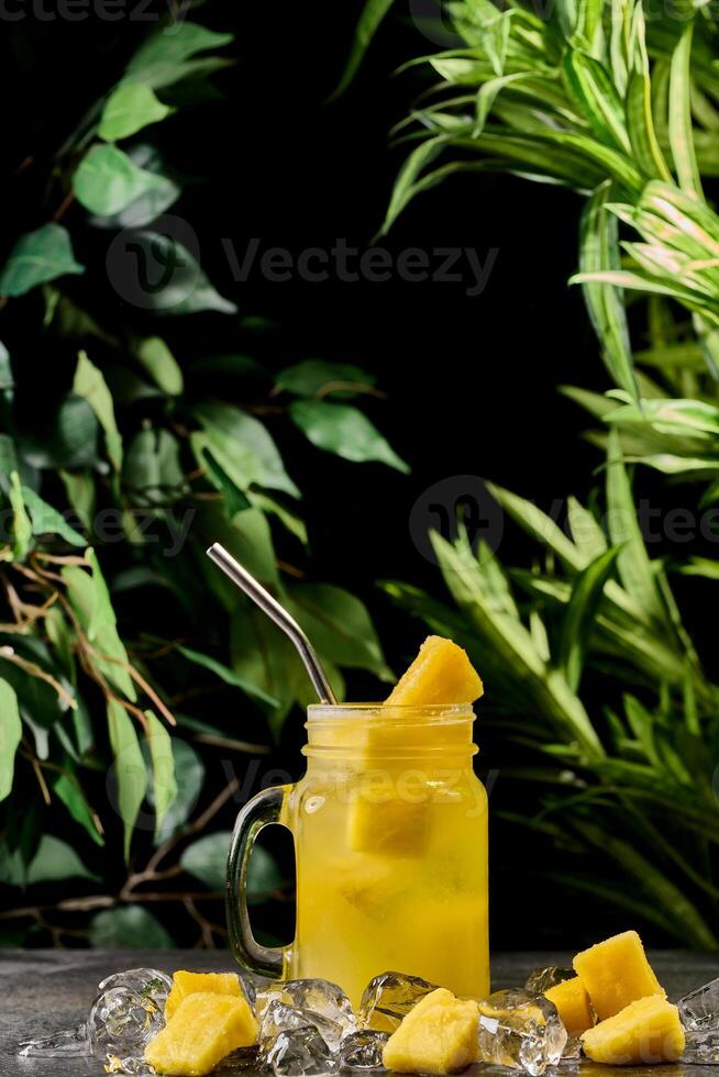 pineapple drink or iced lemonade in a mason jar. Pineapple lemonade with pineapple pieces photo