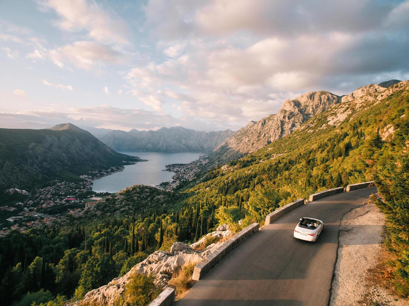 Montenegro, Kotor - July 13, 2024. Convertible drives along a road in the mountains above the Bay of Kotor. Montenegro. Drone photo