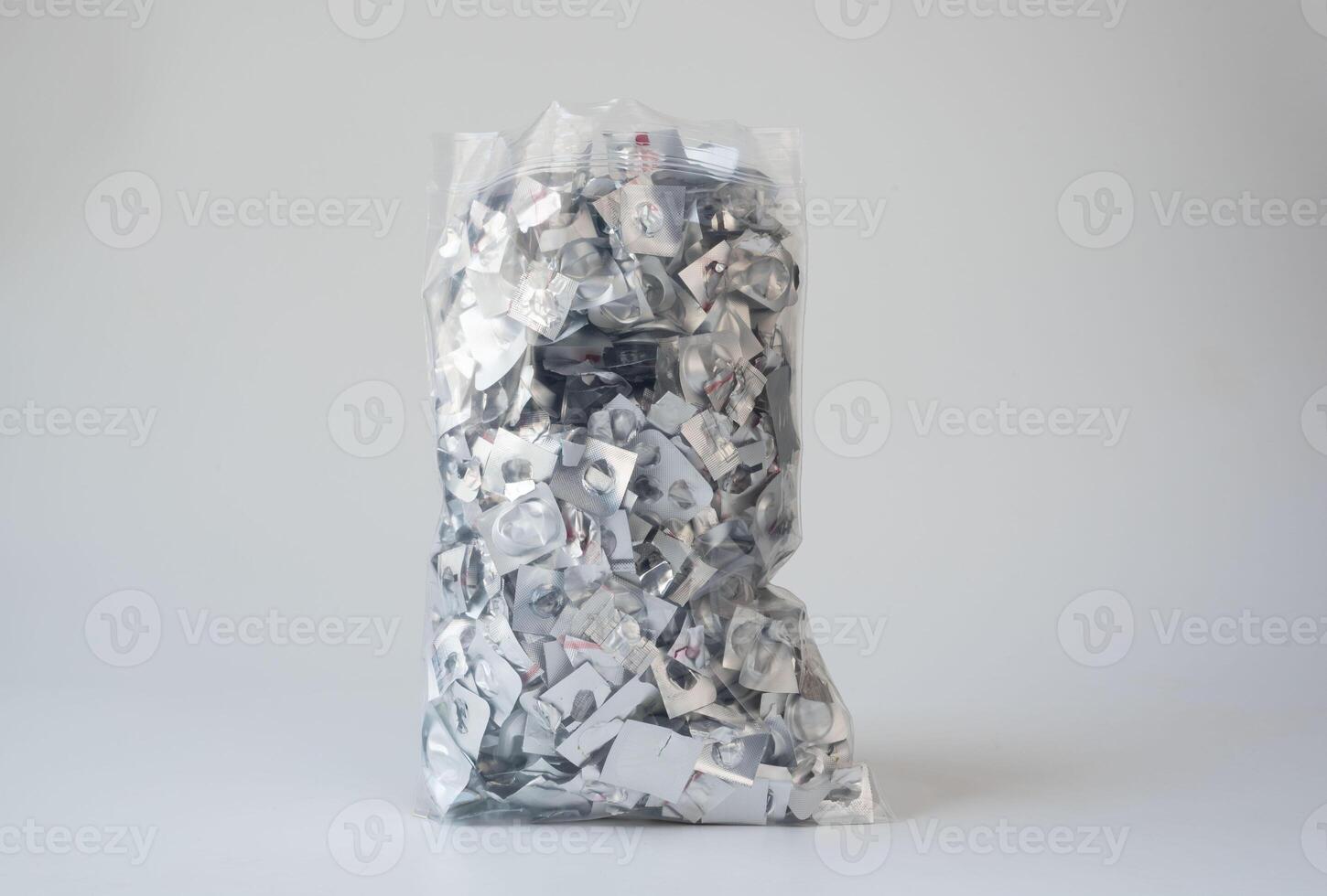 Orphan waste. A clear plastic bag filled with empty aluminum blister pack scraps, highlighting pharmaceutical waste and environmental recycling concerns. photo