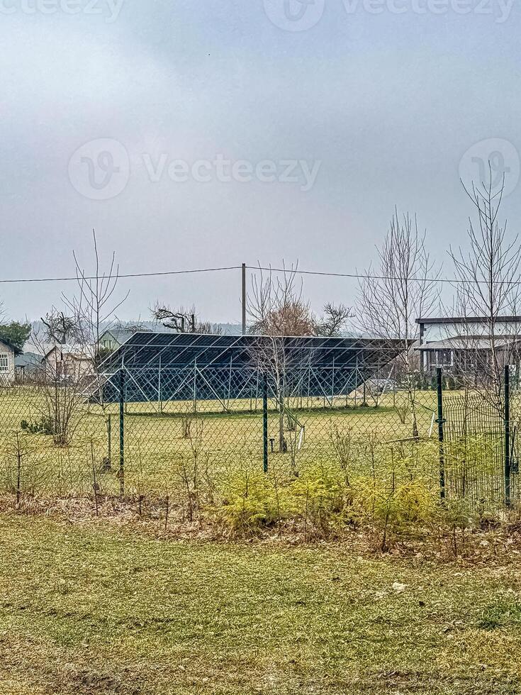 Solar Panel Installation in Rural Field, Overcast Sky, Renewable Energy, Sustainability, Natural Setting. High quality photo