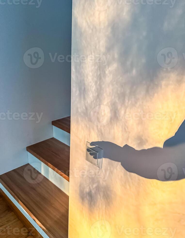 Shadow Hand Turning on Light Switch by Stairs, Interior Scene, Light and Shadow Play, Home. High quality photo