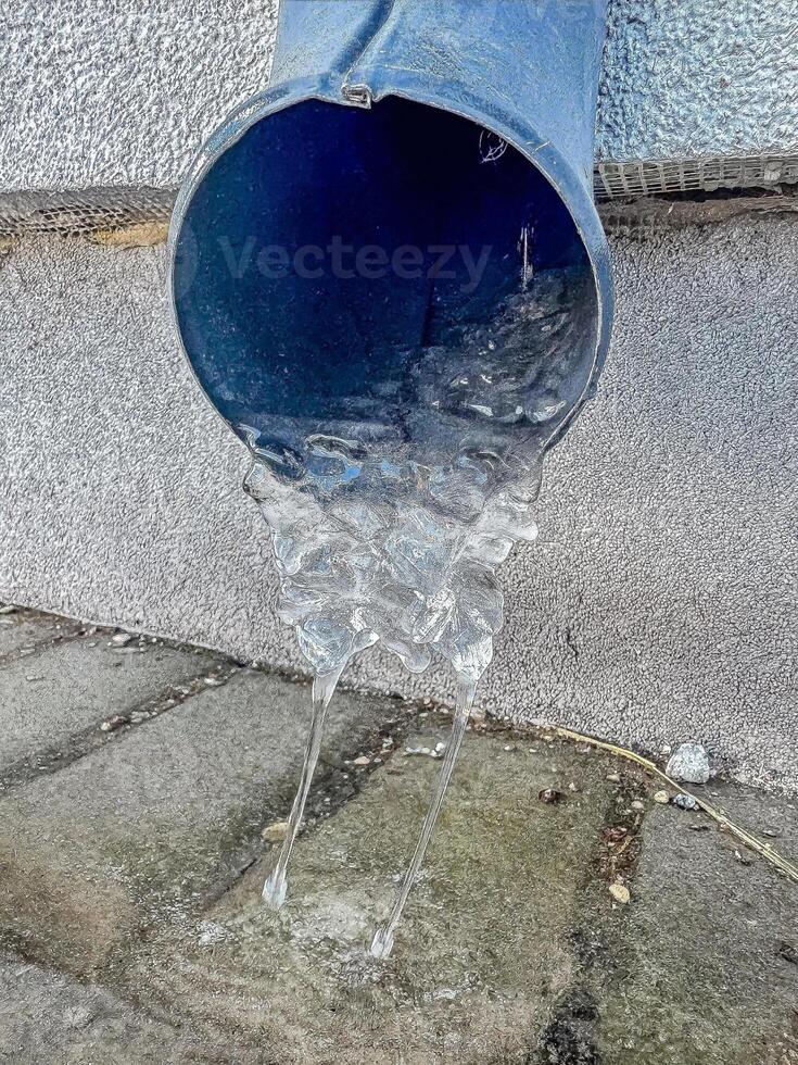 Frozen water in rain pipe of the house. Sudden freezing damages the storm sewer or gutter system. High quality photo