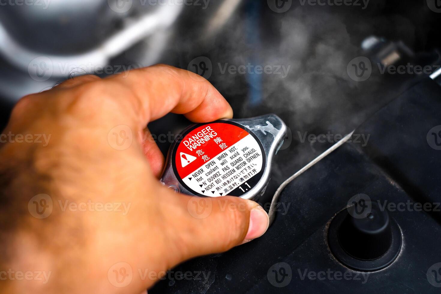 Hand removing the radiator cap from a car radiator while the radiator coolant overheated , Car repair concept photo