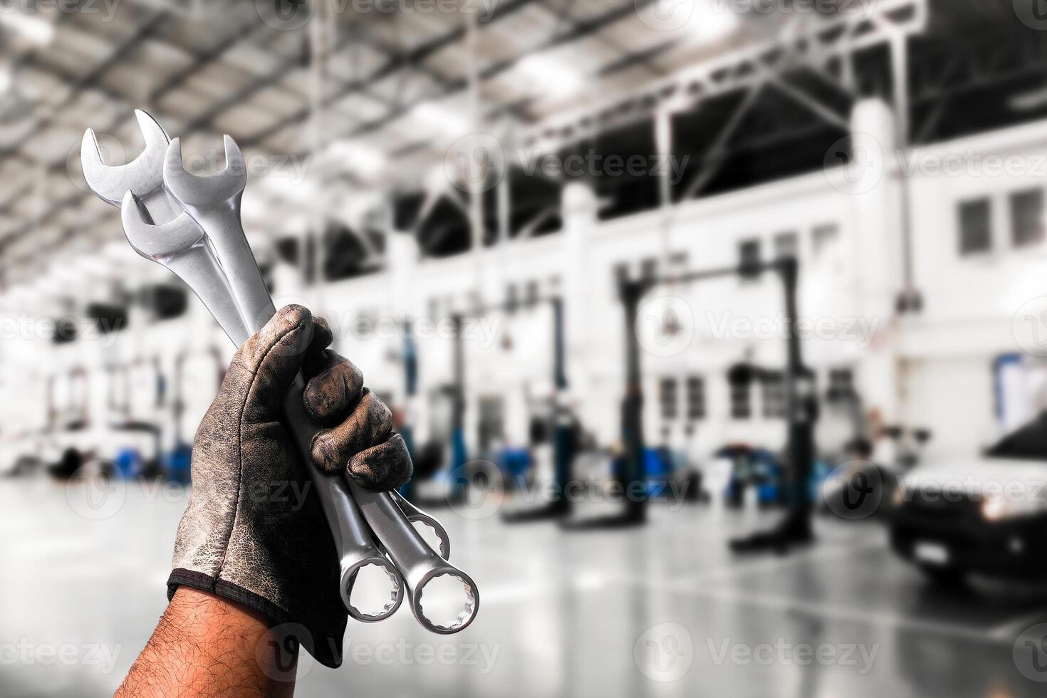Mechanic holding wrenches in automotive workshop , Slim Open-end Wrench in mechanic hand , Automotive repair concept photo