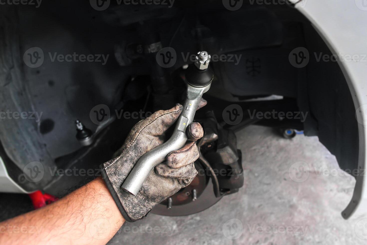 Mechanic holding tie rod end or steering component for car repair photo