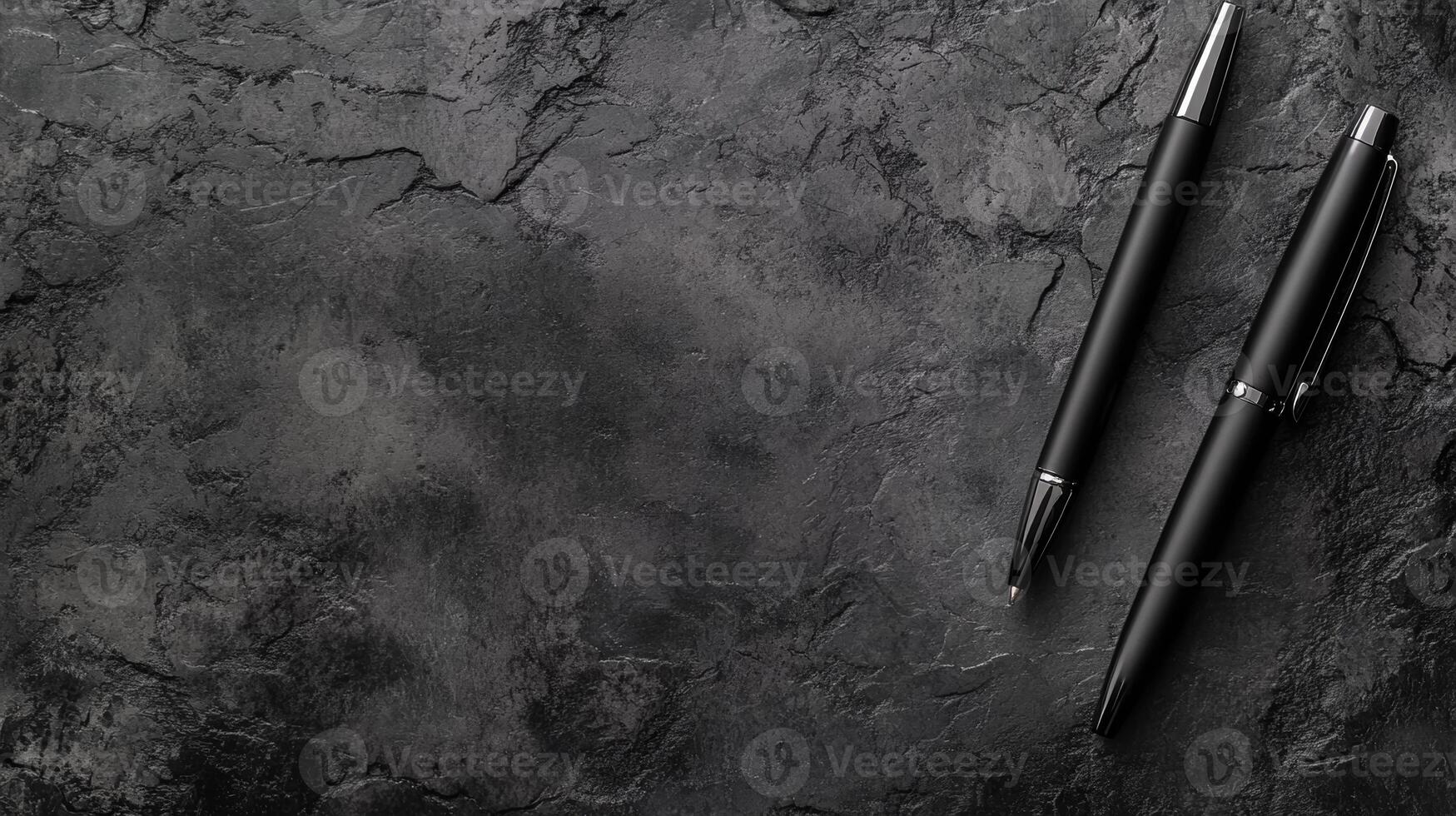 Two Black Pens on a Dark Textured Stone Surface photo