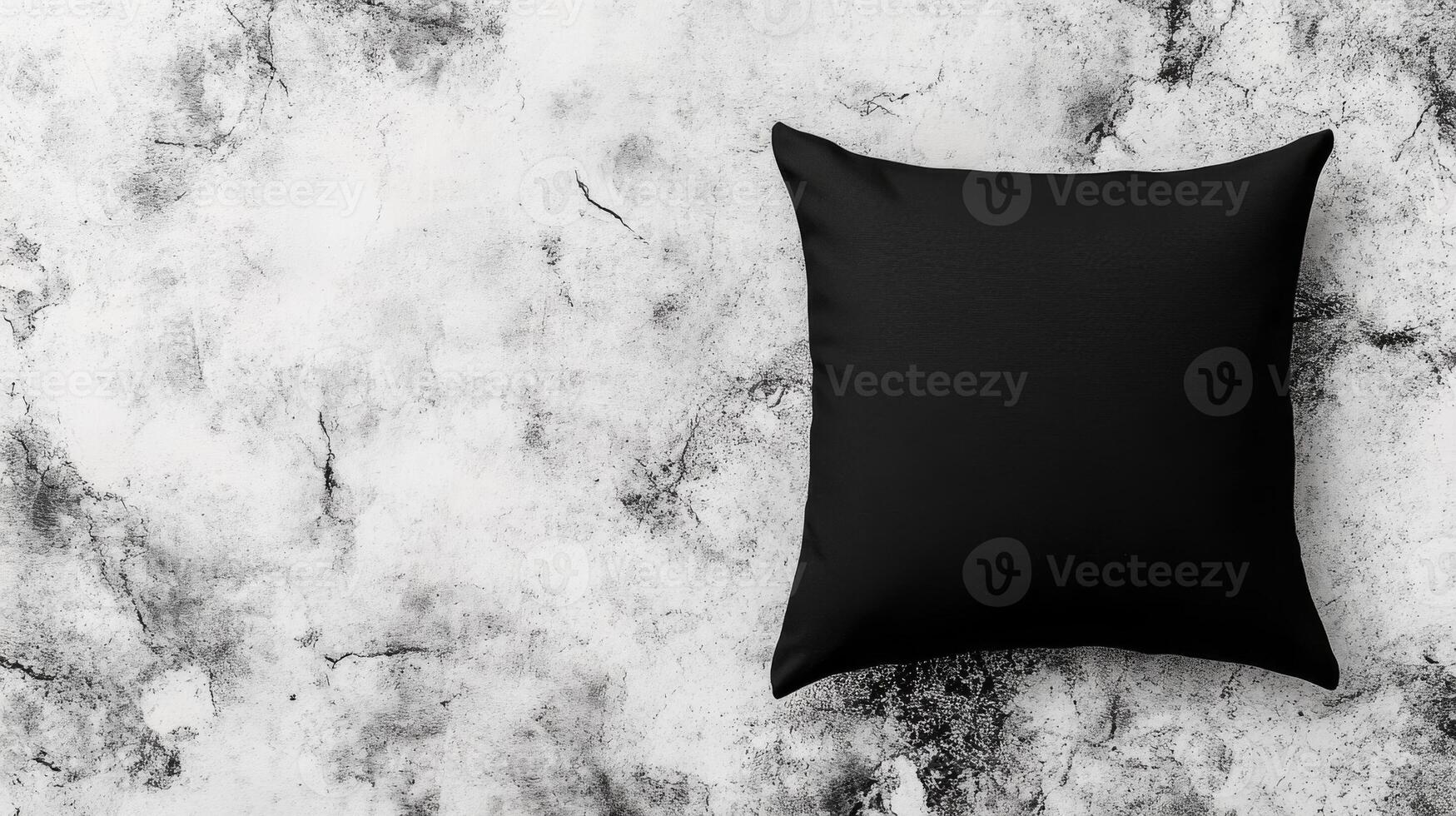 Black Square Pillow on Mottled Concrete Surface, Top View photo