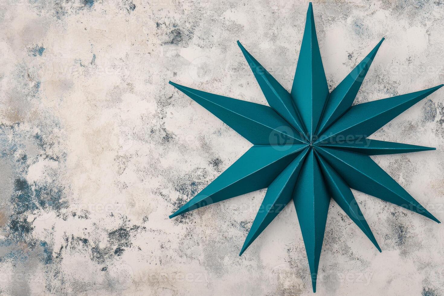 Teal Paper Starburst on a Weathered Gray Stone Surface in Soft Light photo