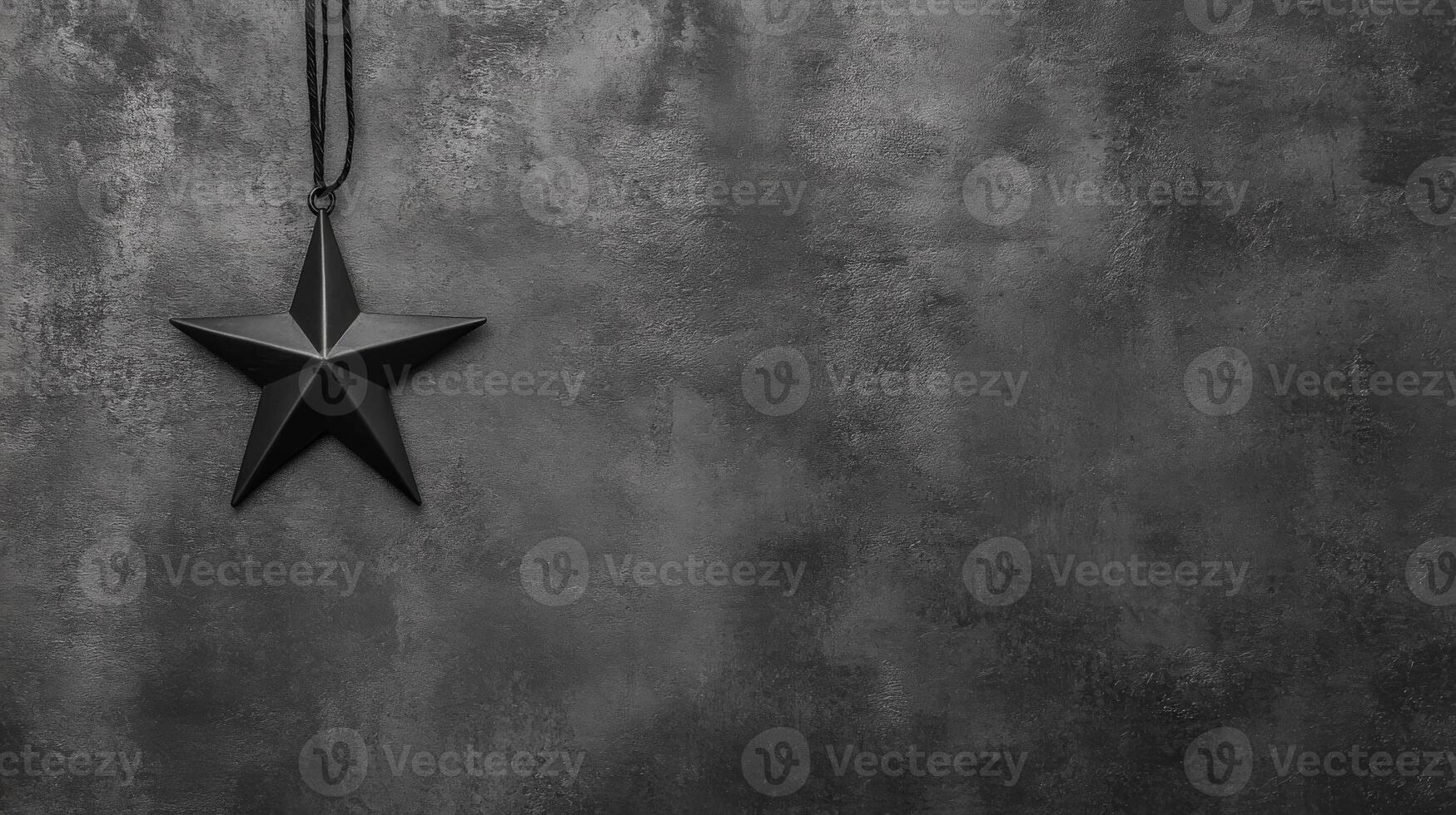 Black Star Pendant Hanging Against a Textured Dark Gray Surface photo