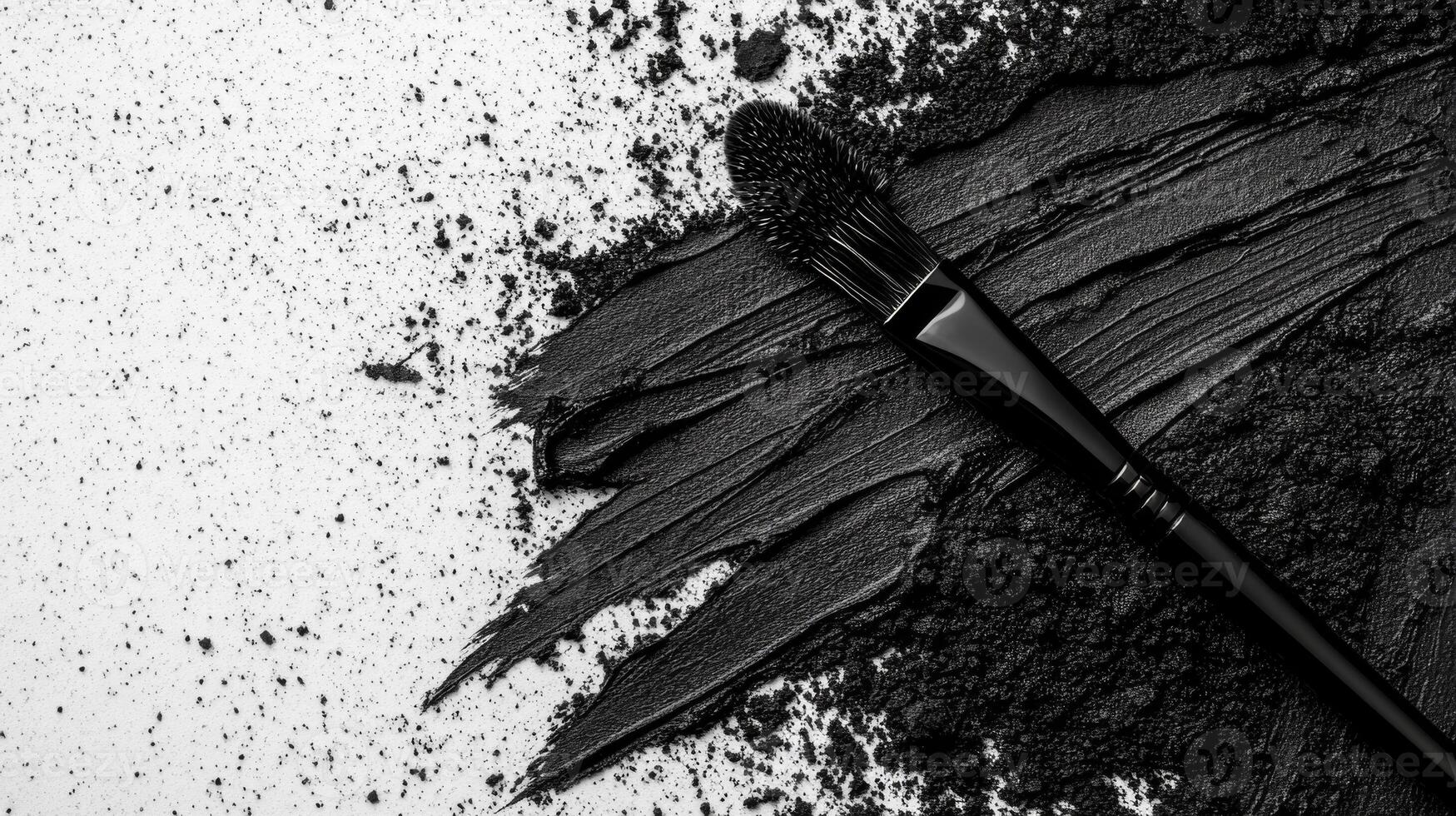 Black Makeup Brush with Smudged Charcoal Powder on a Gradient Surface photo