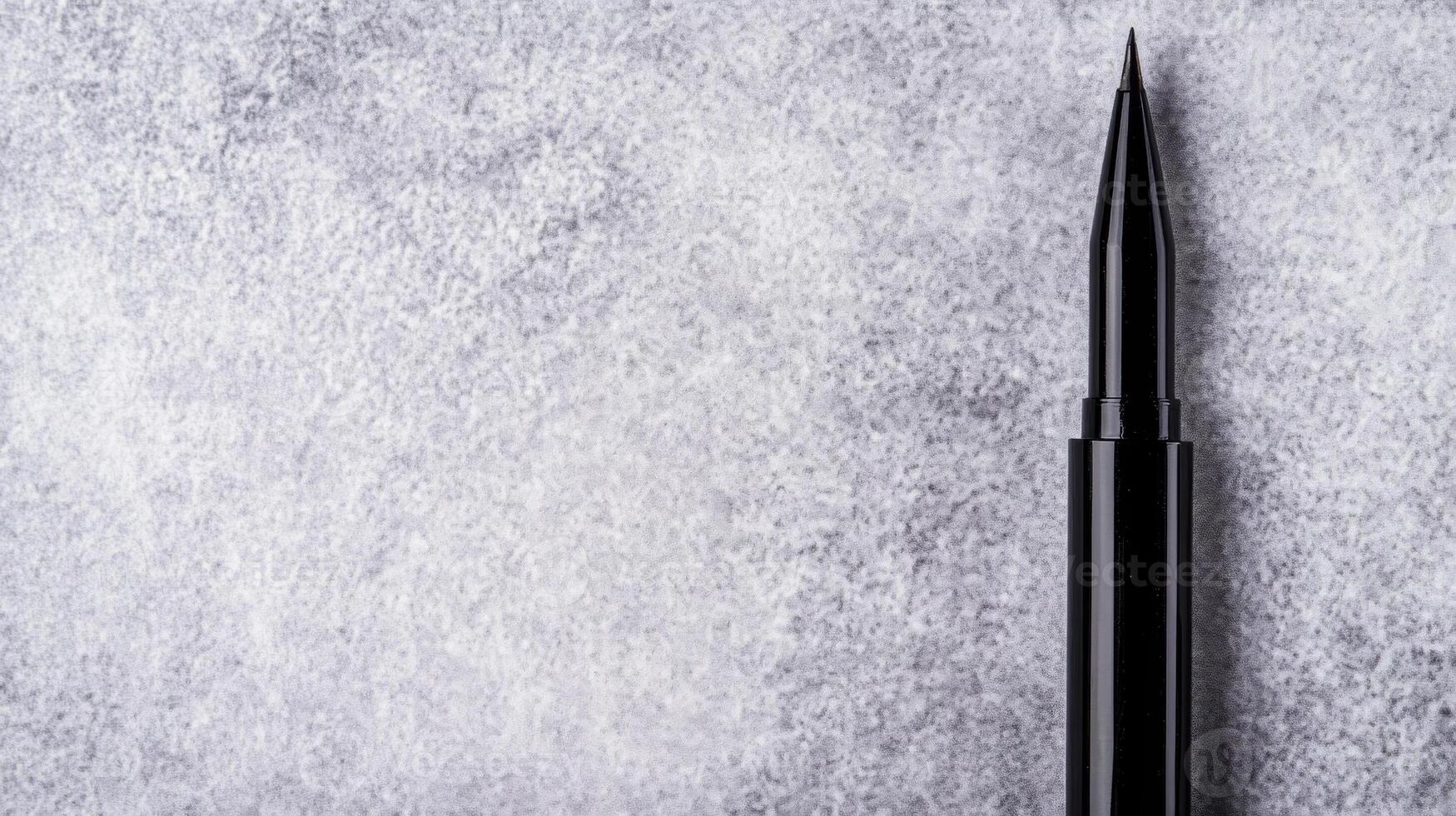 Black Eyeliner Pen on a Subtle Gray Textured Surface photo