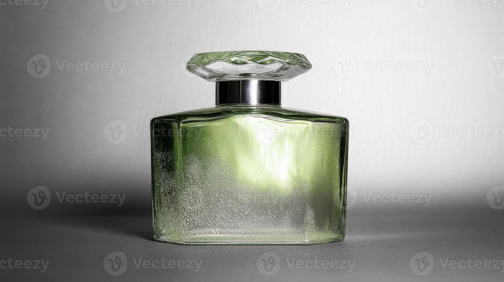 Green Perfume Bottle with Faceted Cap on a Smooth Gray Surface photo