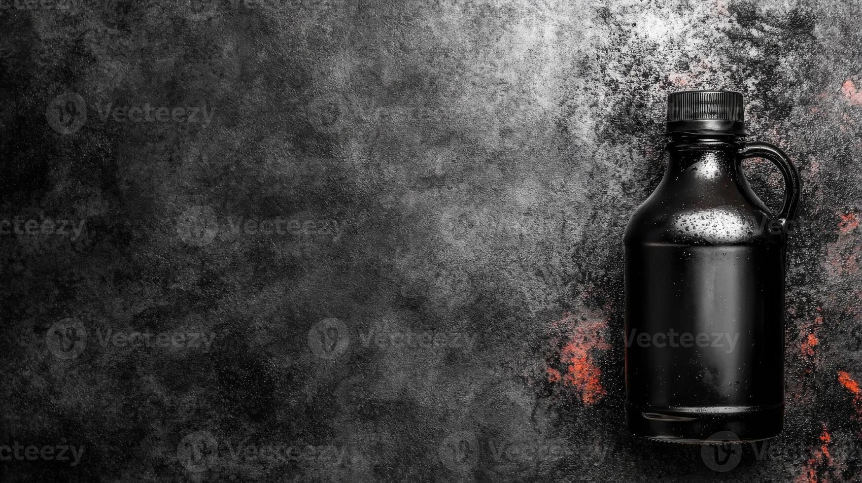Black Jug with Handle on a Dark Textured Surface with Rust Spots photo