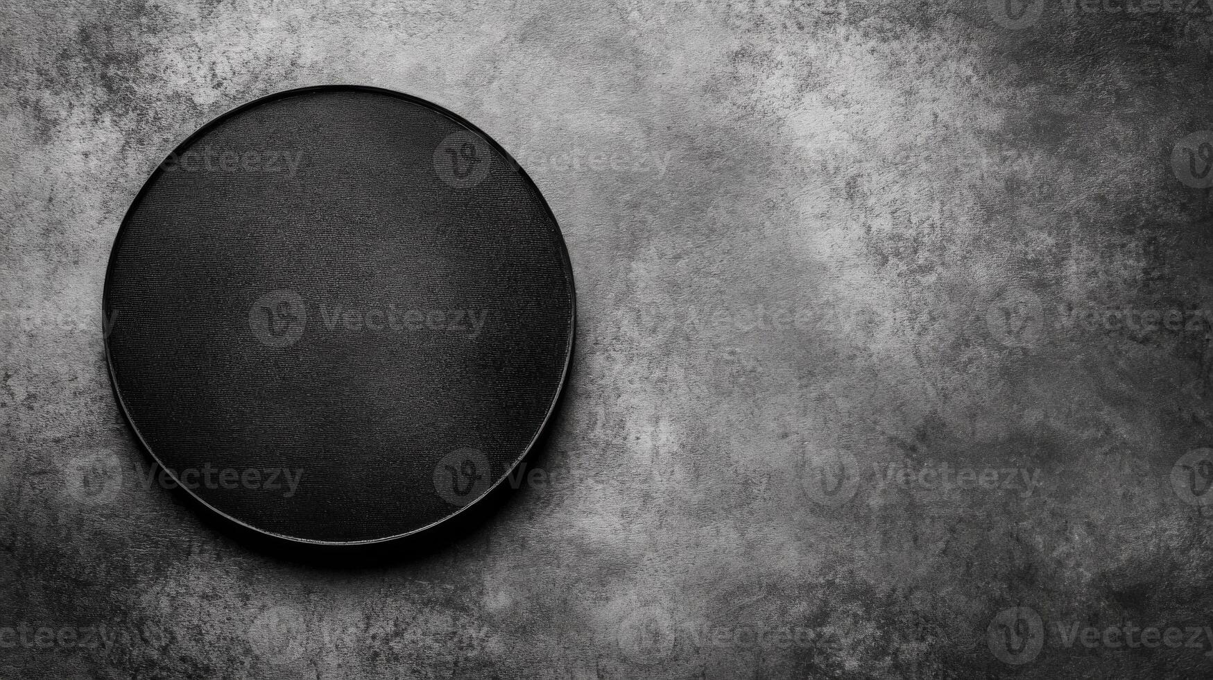 Black Circular Container on a Textured Gray Stone Surface photo