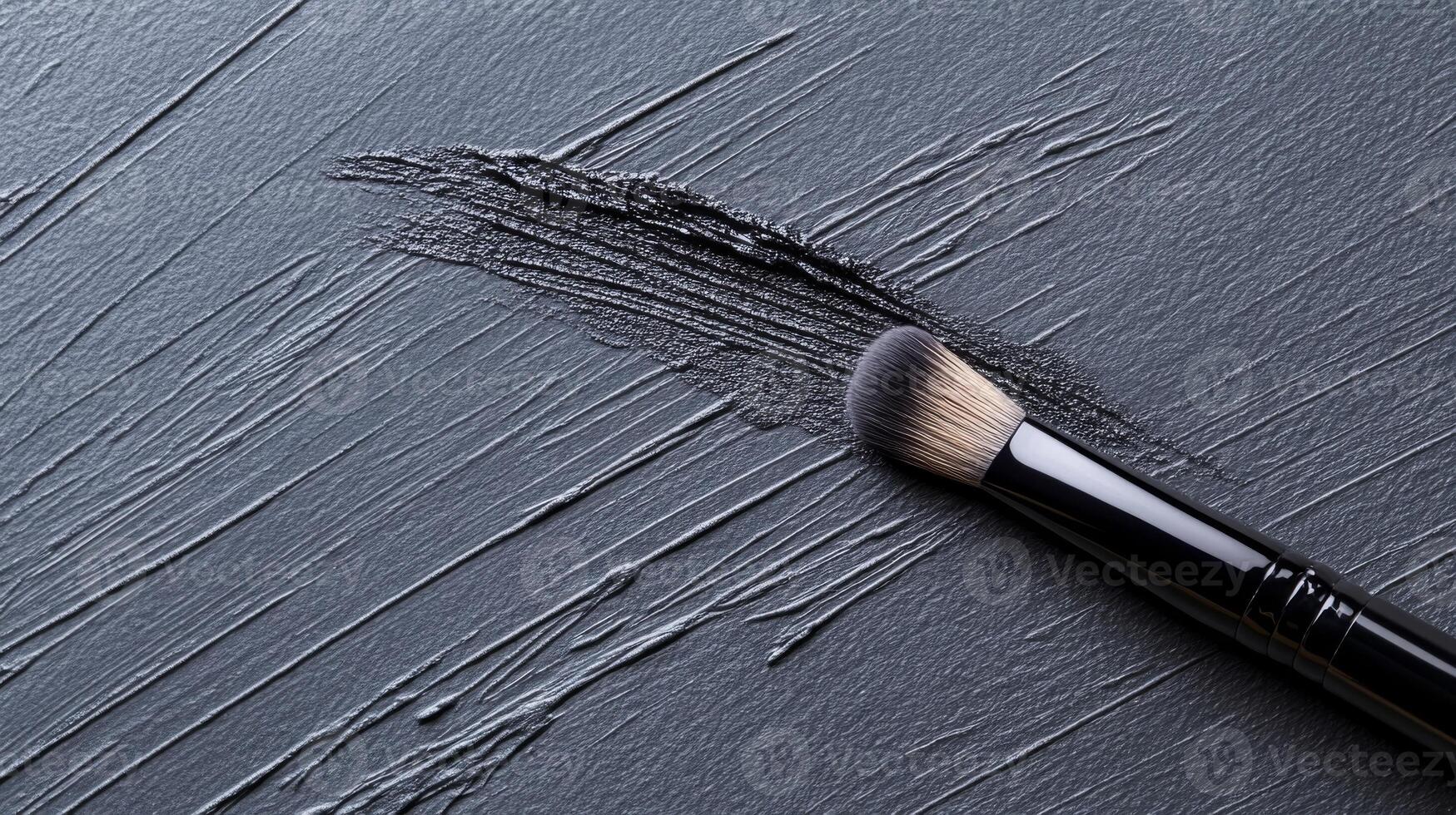 Makeup Brush with Black Smudge on a Textured Dark Surface in Monochrome photo