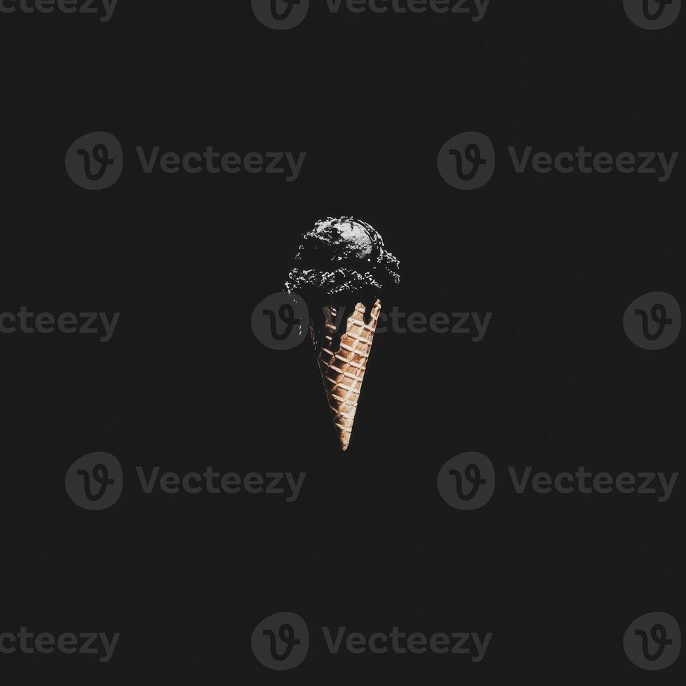 A Single Dark Ice Cream Scoop in a Waffle Cone Against a Black Background photo