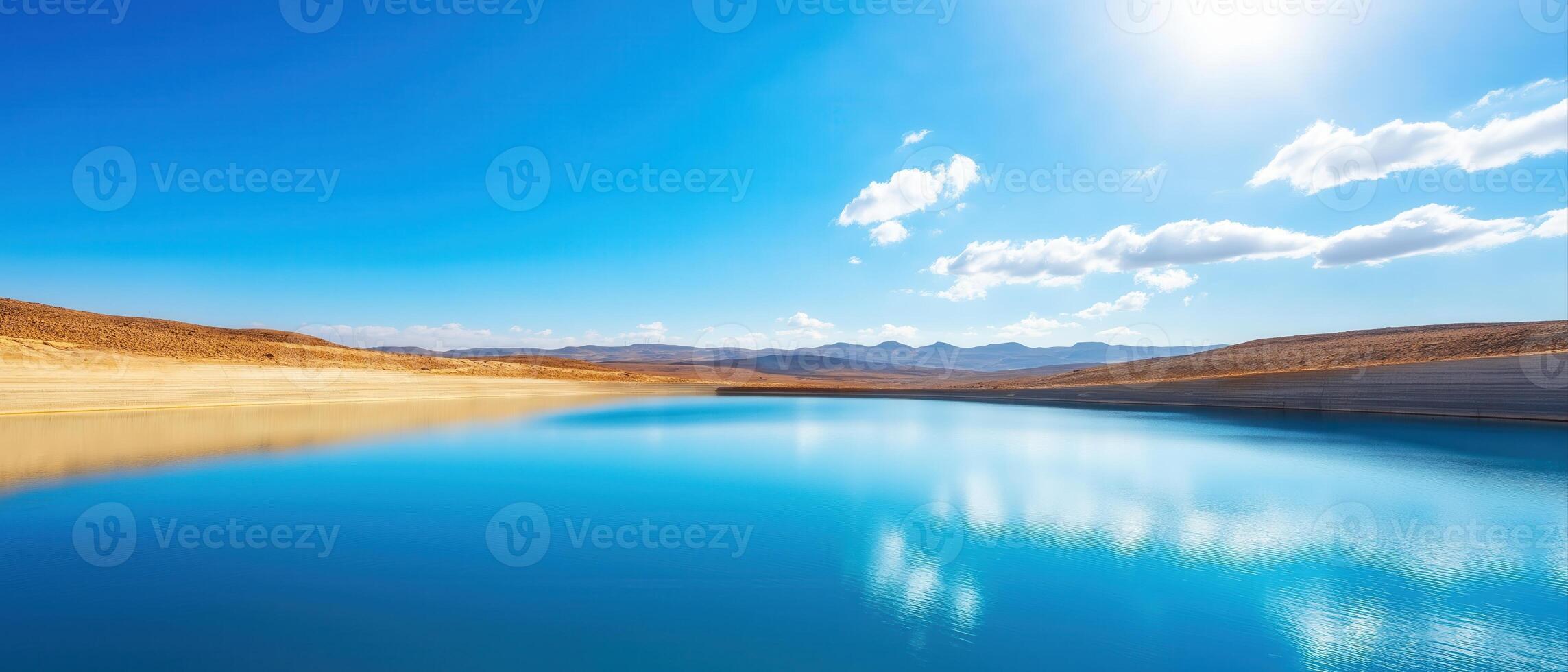 Large Dam with Low Water Levels Under Bright Blue Sky and White Clouds photo