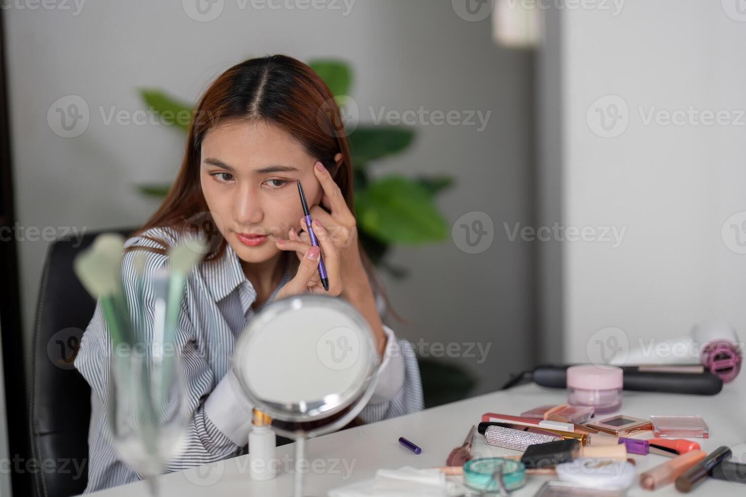 Beauty and Eyebrow Styling. A woman applying eyebrow pencil to shape her brows in a chic manner. photo