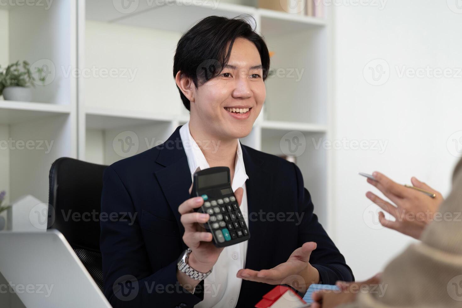 Financial Planning and Real Estate Consultation. A real estate agent engages clients with investment calculations. photo
