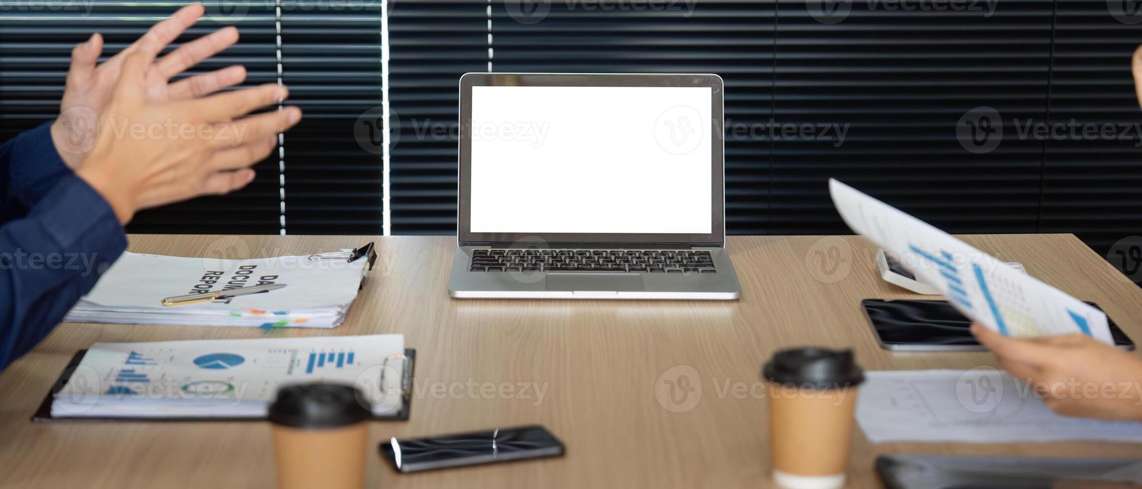 Financial Collaboration in Focus. A team meeting discussing reports with a laptop in view. photo