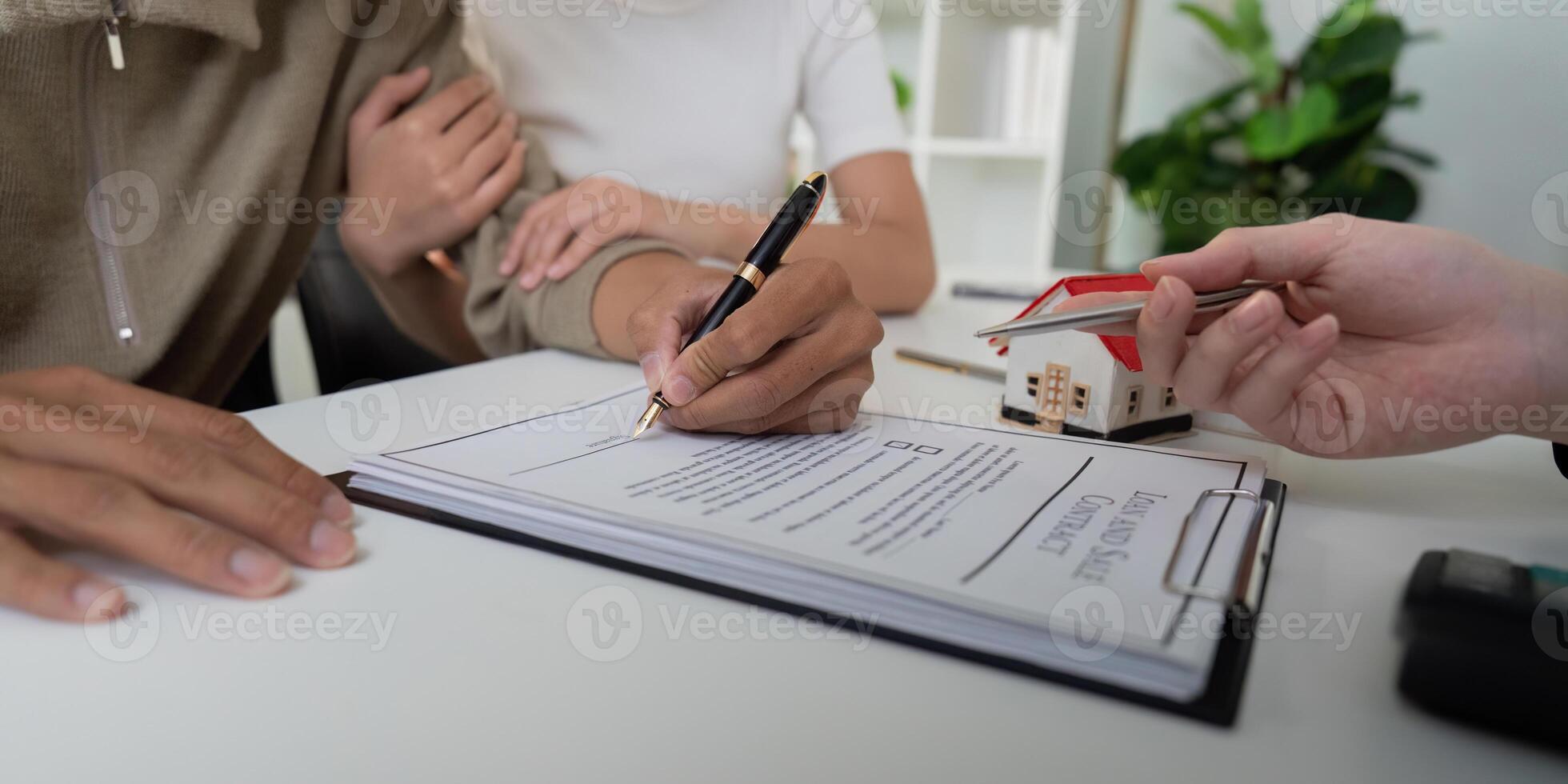Contract Signing and Home Ownership. A couple finalizing their real estate deal, signing essential documents with a supportive agent. photo