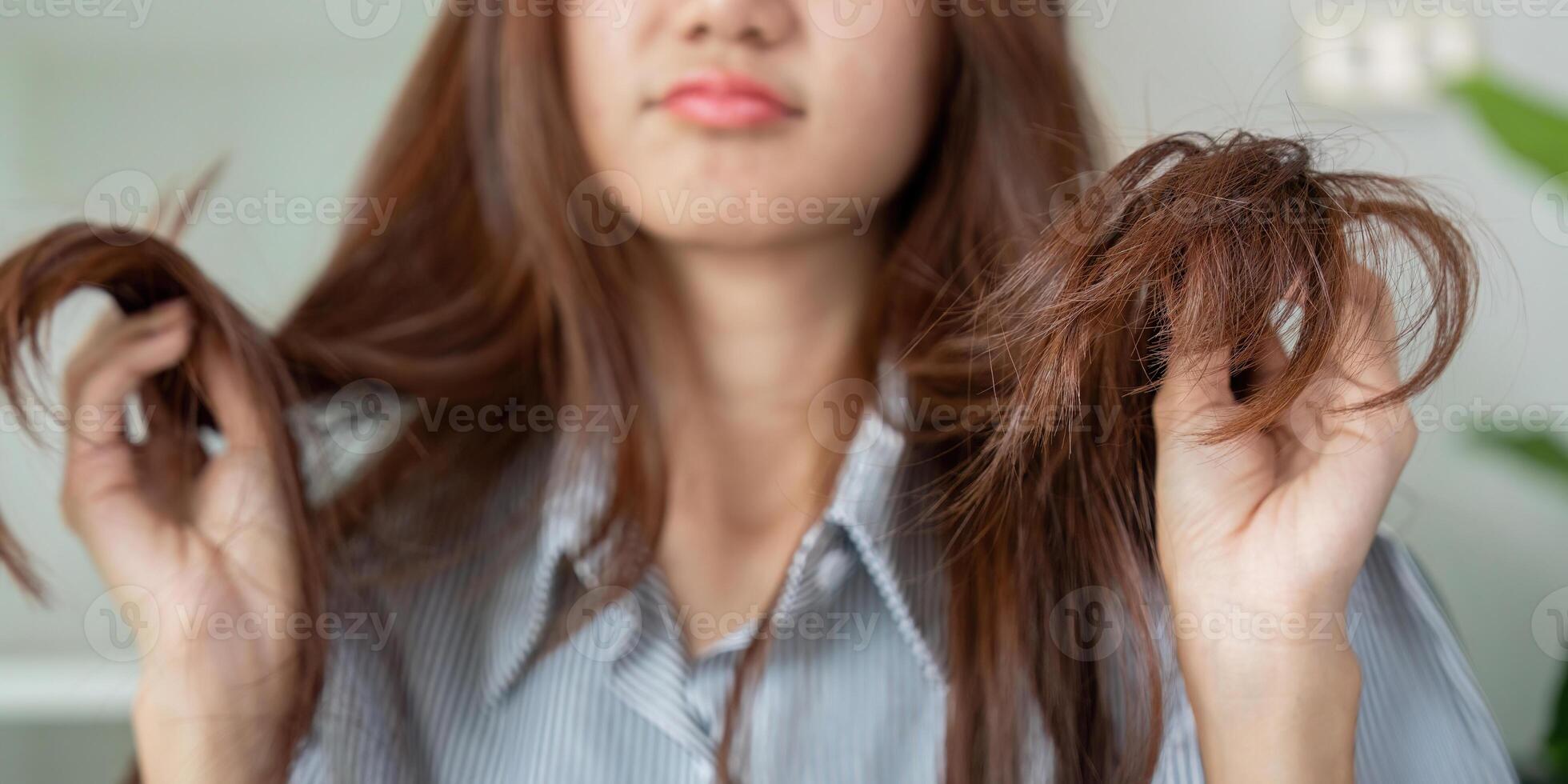Frizz Management and Hair Troubles. A woman expresses frustration with her frizzy hair, showcasing common beauty struggles. photo