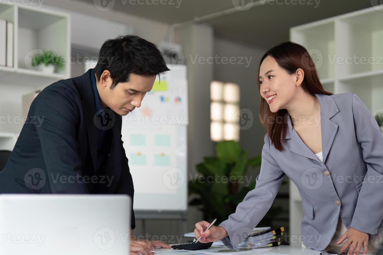 Collaboration and Innovation. Two colleagues discussing project details at a desk in a professional setting. photo