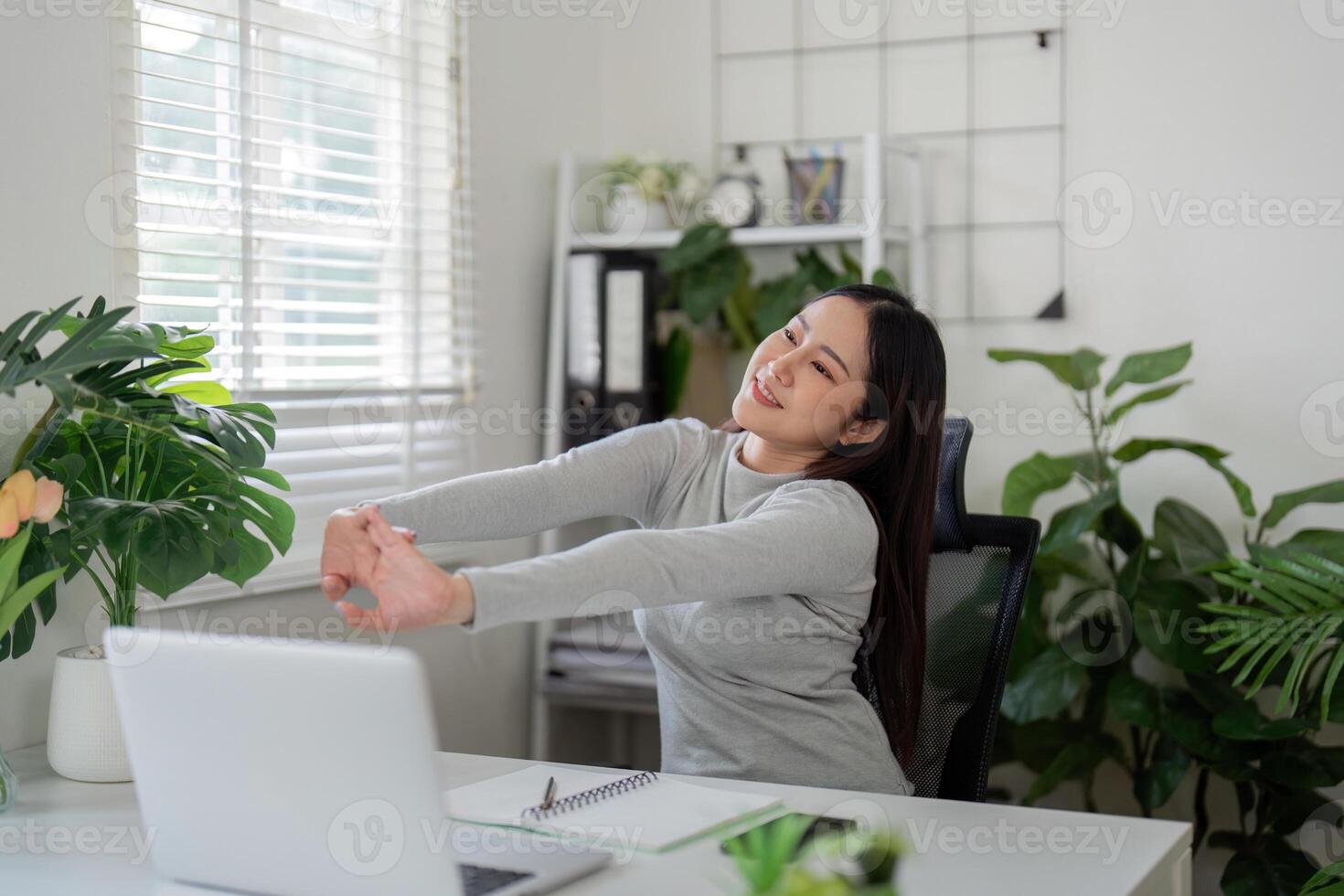 Wellness and Stretching. A woman takes a moment to stretch during her work-from-home routine. photo