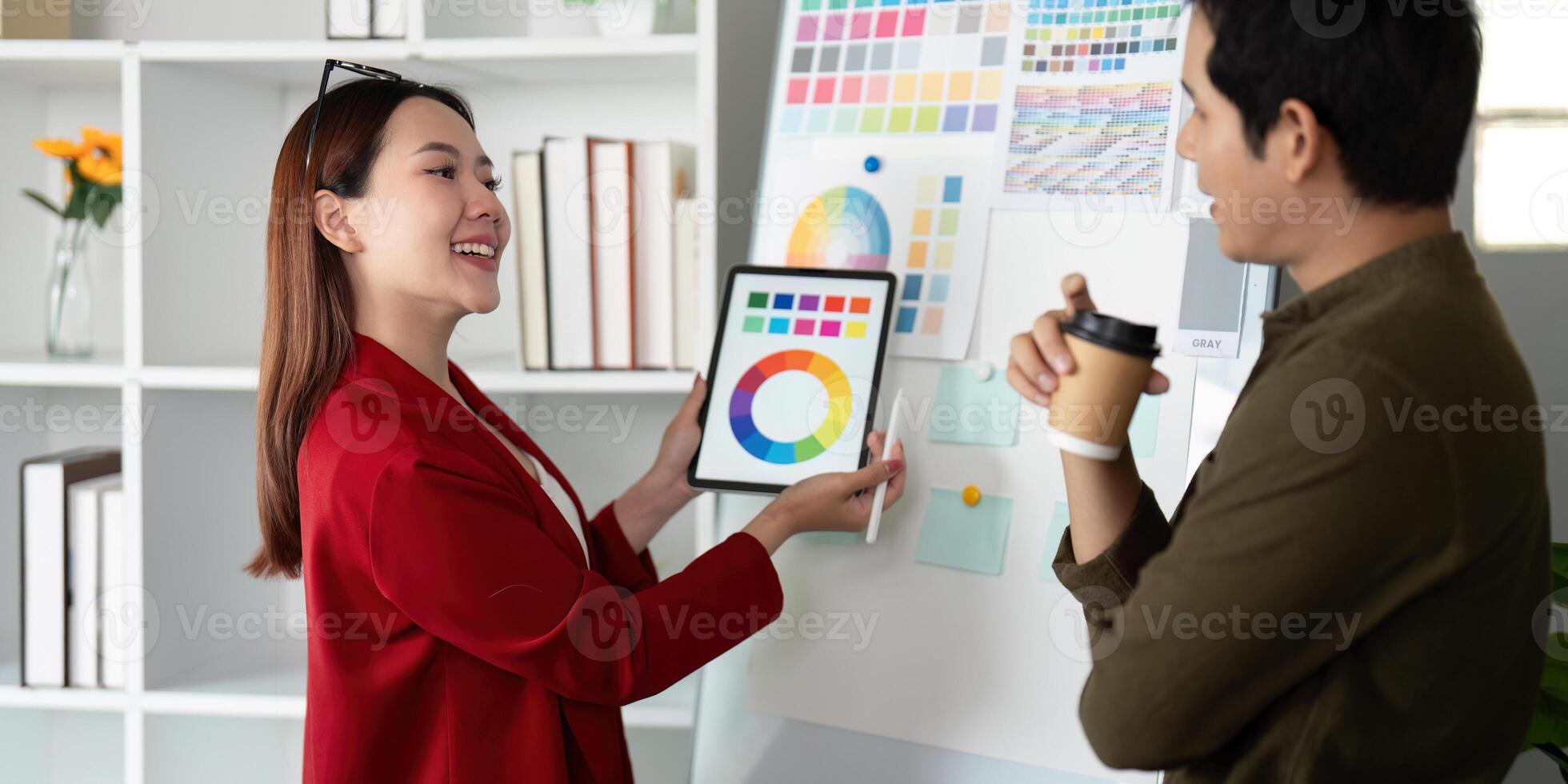 Presentation and Feedback. A designer showcases color palettes using a digital tablet to encourage creative dialogue. photo