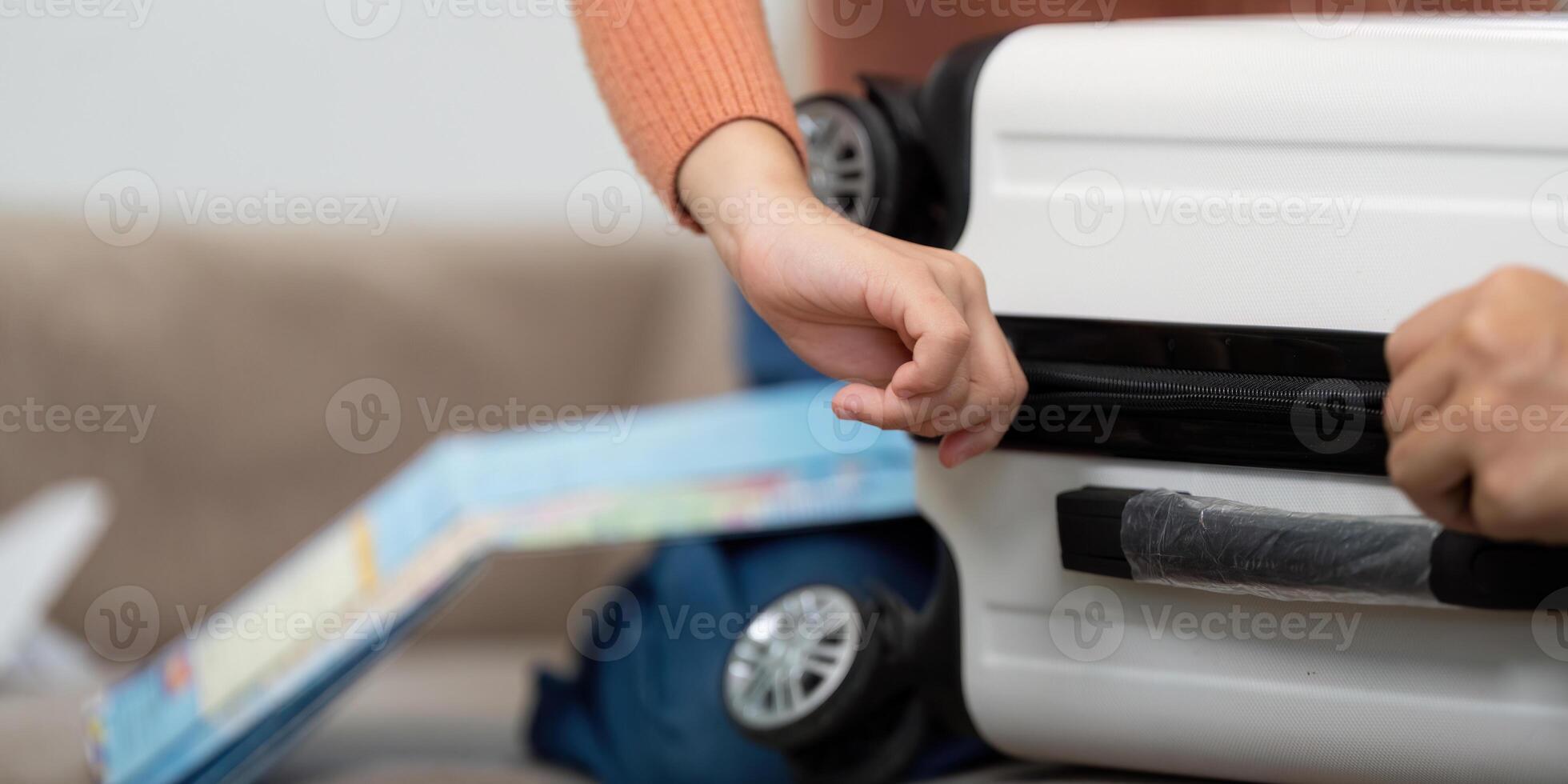 Exploring Maps and Travel Essentials. A close-up of a child's hand reaching for travel essentials while packing. photo