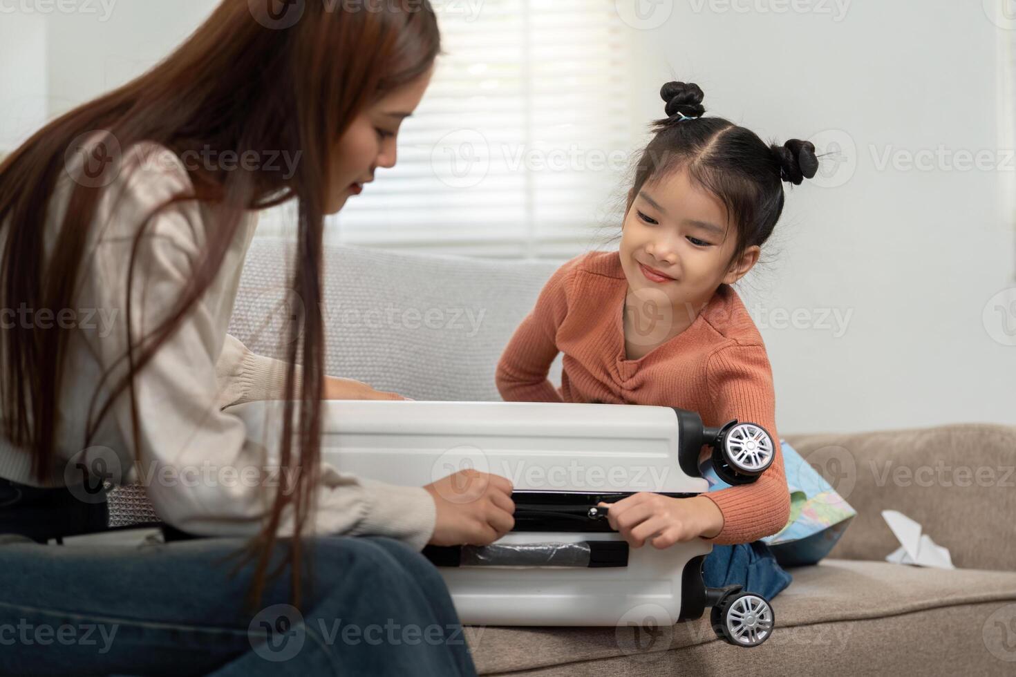 Travel Preparation and Family Bonding. A mother and daughter packing a suitcase together for an upcoming trip. photo