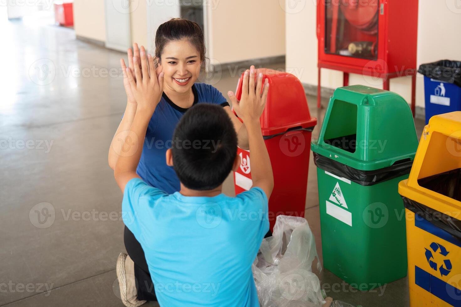 Playful Learning and Recycling. A child and a teacher share joy while learning about waste sorting. photo