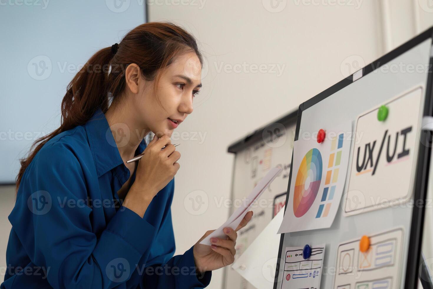 Innovative UX UI Design Discussion. A designer thoughtfully examines a user experience board with visuals. photo
